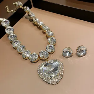 Close-up of luxury heart-shaped crystal pendant necklace and matching stud earrings set