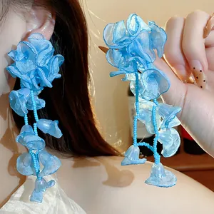 Detail view of long blue chiffon flower tassel earrings with delicate blue beadwork.