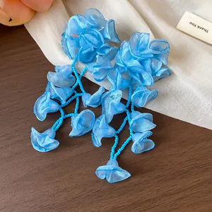 Close-up of elegant blue chiffon flower tassel earrings with delicate bead strings