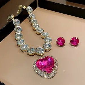 Close-up showing the sparkling magenta heart gemstone and clear crystal necklace details