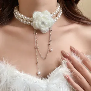 Close-up of double-layer pearl necklace with a white knitted flower centerpiece