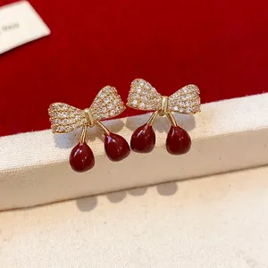 Boucles d'oreilles cerise à nœud dorées avec zircons étincelants et émail rouge