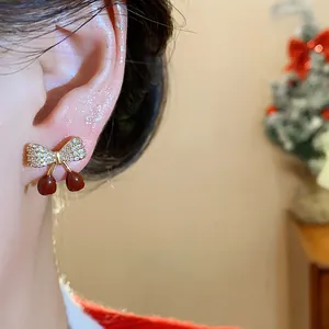 Gros plan détaillé d'une boucle d'oreille nœud cerise élégante avec zircons sur l'oreille