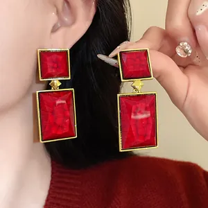 Detailed macro view of vintage geometric red square earrings with elegant gold frames