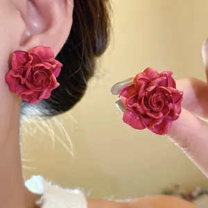 Detail view of vintage red resin rose stud earrings with premium silver needles.