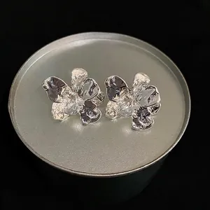 Elegant silver textured flower stud earrings with a minimalist metallic finish