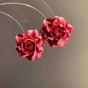 Detailed macro view showing the textured petals of vintage red resin rose flower stud earrings