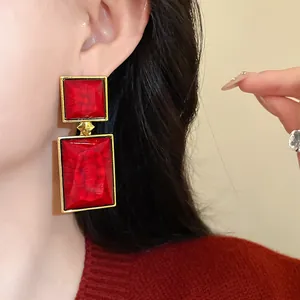 Close-up of vintage geometric red stone earrings with elegant gold framing