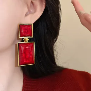 Detailed close-up view of vintage red geometric drop earrings with elegant gold-tone borders.