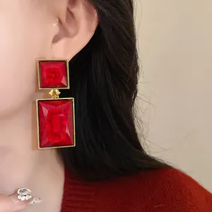 Close-up of red geometric vintage square drop earrings with gold frame