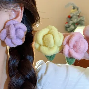 Close-up showing the soft texture of handmade flocked flower earrings in 3 colors