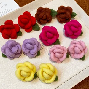 Close-up view of multiple colorful flocked rose stud earrings arranged on a textured tray