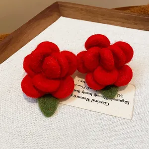 Detailed macro view of red flocked flower stud earrings showing soft velvet-like texture