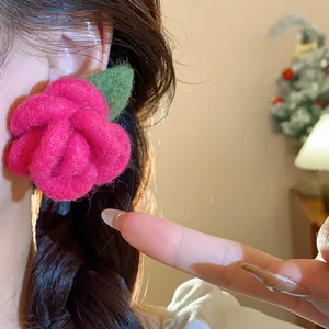 Detailed view of a sweet pink flocked flower stud earring worn on an Asian model's ear