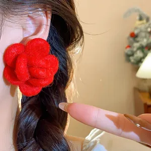 Detailed close-up showing a vibrant red flocked flower stud earring worn on ear
