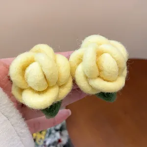 Detailed view of yellow flocked flower stud earrings with realistic petal texture