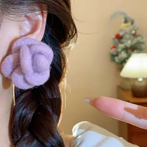 Macro detail of elegant purple flocked flower stud earrings with a soft felt texture