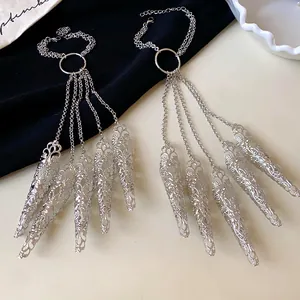 Detailed view of silver hollow filigree nail claw covers with elegant tassel chain accents