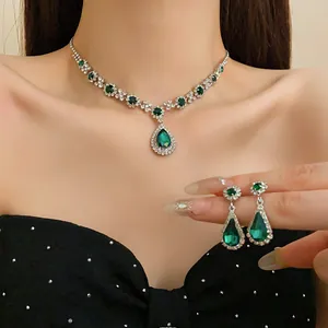 Elegante set di collana e orecchini a goccia verde smeraldo mostrato sul modello