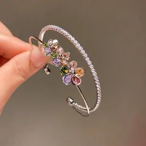 Detailed view of two-layer silver-tone bangles with colorful zircon flowers and clear stones