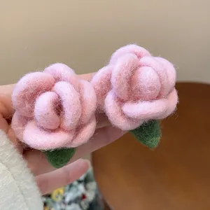 Close-up of pink flocked rose earrings with detailed velvet-like texture.