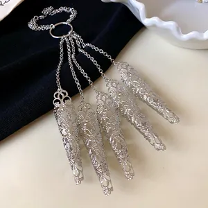 Detail shot of silver nail cover bracelet with intricate hollow filigree pattern