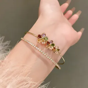 Detailed shot of a gold double-layer open bracelet with colorful zircon flowers.