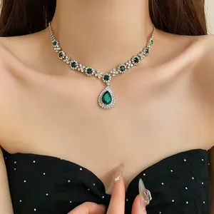 Elegante collana con pendente a goccia verde smeraldo e cristalli scintillanti sul modello