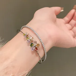 Detailed view of elegant double-layer open bangle with zircon flowers worn on female wrist