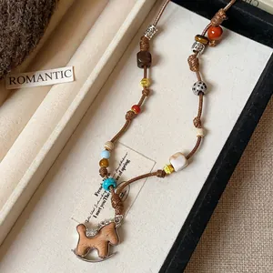Close-up of handmade woven rocking horse necklace with textured multi-color beads