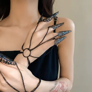 Close-up macro view of gothic black hollow pattern nail armor and chain bracelet set