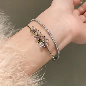 Close-up detail of silver-tone double-layer bangle featuring colorful zircon flower motifs