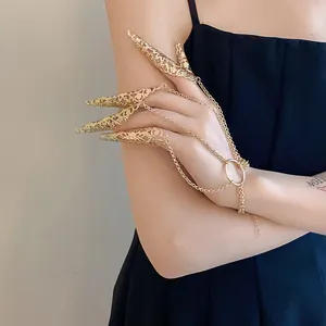 Detailed view of exquisite hollow patterned gold finger claws with chain bracelet