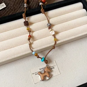 Detailed close-up of a hand-woven leather necklace with a rocking horse pendant