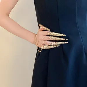 Detailed macro view of an intricate golden filigree nail guard ring and bracelet set