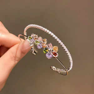 Detail of double-layer open bangle with colorful zircon flowers and sparkling stones.