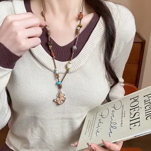 Detailed view of handcrafted rocking horse necklace with colorful beads on a model.