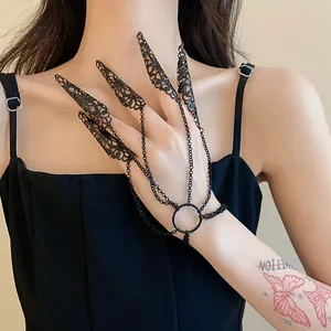 Detail of gothic black filigree hollow nail rings connected to a delicate chain bracelet