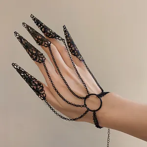 Detail of black filigree claw ring set with connecting chains and wrist bracelet link.