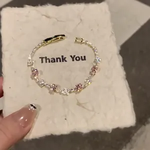 Gold plated geometric tennis bracelet featuring pink and clear cubic zirconia stones