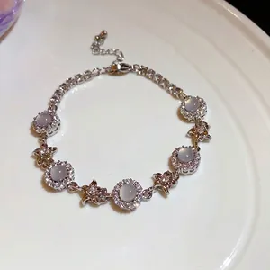 Elegant silver-tone chalcedony flower bracelet with zircon stones on a white ceramic plate