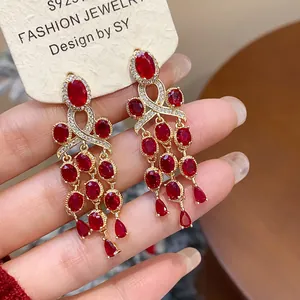 Vue rapprochée de boucles d'oreilles à pompons en zircon rouge de style palais vintage.
