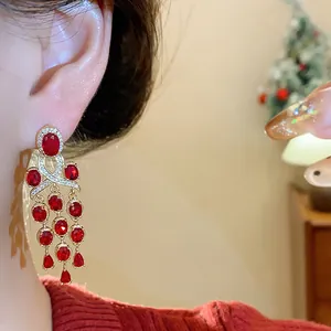 Détail de boucles d'oreilles vintage en zircon rouge avec pompons ovales et brillants