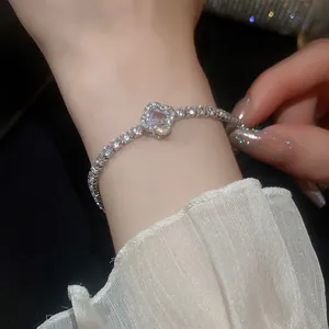 Close-up of sparkling zircon flower bracelet with gold plating on female wrist