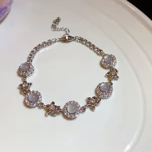 Macro detail of elegant silver zircon chalcedony flower bracelet displayed on white ceramic