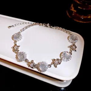Close-up of an elegant flower charm bracelet featuring white chalcedony and sparkling zircons