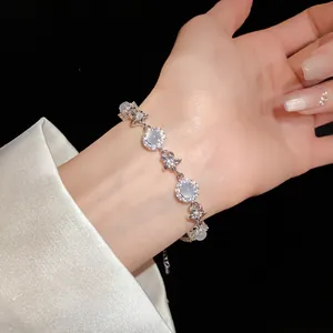 Detail shot of elegant zircon and chalcedony flower bracelet worn on a woman's wrist