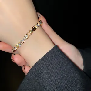 Close-up of elegant gold-plated zircon bracelet with sparkling oval geometric stones