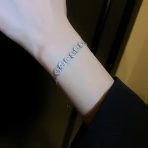 Close-up of a sparkling cubic zirconia bracelet on a wrist with elegant dark background.