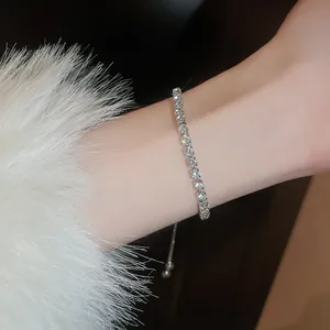 Close-up of elegant silver-colored zirconia tennis bracelet on wrist with fur sleeve